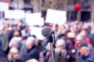 Close-up of microphone with people in background