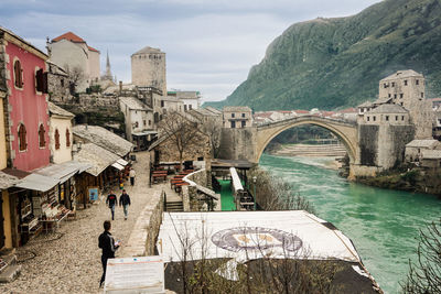 People on bridge over buildings in city