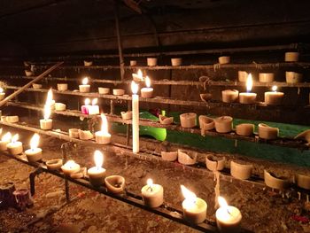 Close-up of illuminated candles in temple