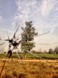 View of field against cloudy sky