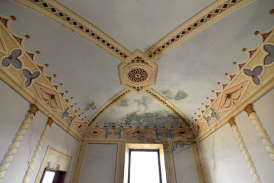 Low angle view of chandelier hanging on ceiling of building