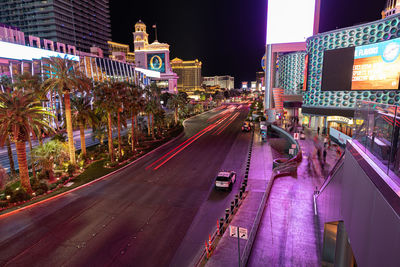 Panoramic view of city street amidst buildings at night