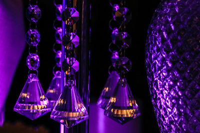 Close-up of illuminated lighting equipment hanging at night