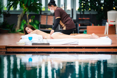 People relaxing by swimming pool