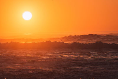 Scenic view of sea against orange sky