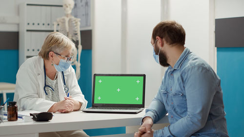 Side view of female doctor working in office