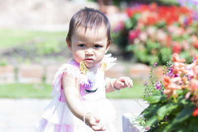 Portrait of cute baby girl against plants