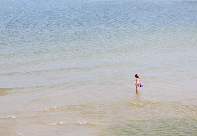 Rear view of woman standing on beach