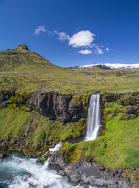 Scenic view of waterfall against sky