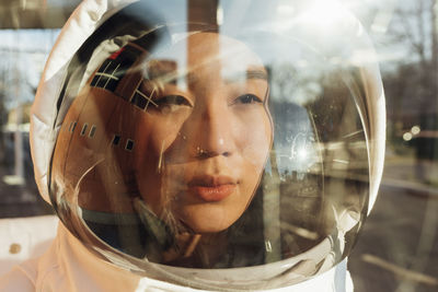 Female astronaut looking away wearing helmet during sunny day