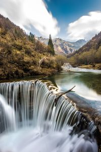 Scenic view of waterfall against sky