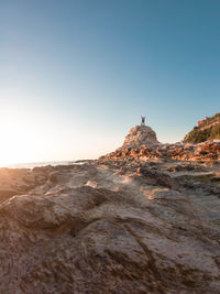 Man on rock formation at beach