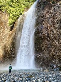 Rear view of man looking at waterfall