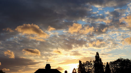 Low angle view of silhouette trees against sky