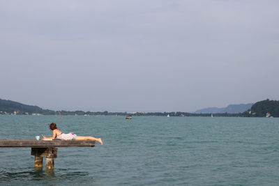 Young woman in sea against clear sky