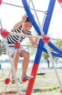 Full length of girl on jungle gym at playground