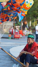 Senior man selling balloons on street