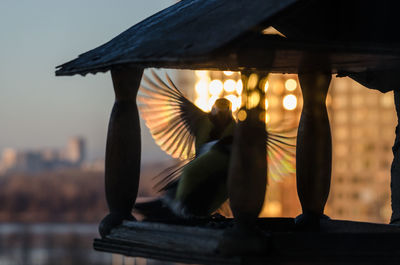 Close-up of silhouette candle on table against sky during sunset