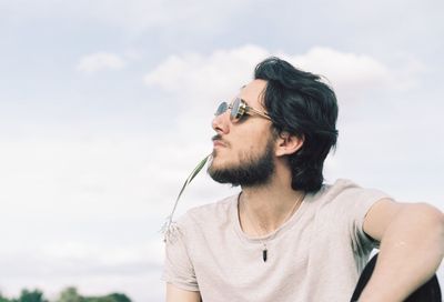 Portrait of young man against sky