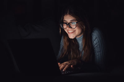 Portrait of young woman using laptop at home