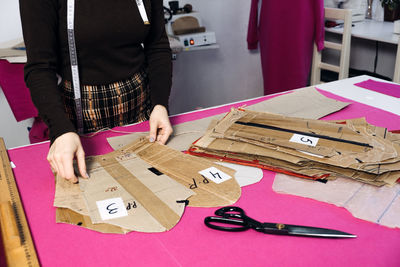 Sewing sustainable fashion industry. seamstress working with clothing and sewing pattern on table