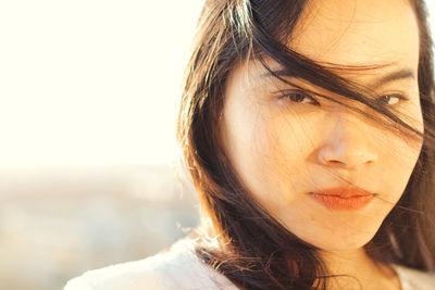 Close-up portrait of woman outdoors in sunny day