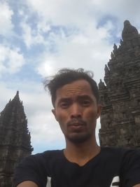 Portrait of man in temple against sky