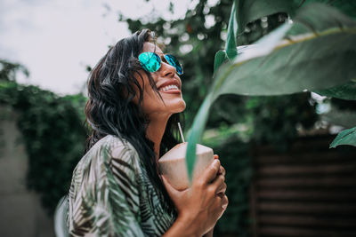 Portrait of a smiling young woman drinking water