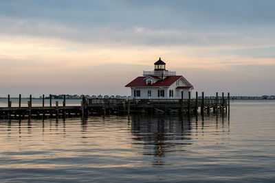 Pier on sea against sky during sunset