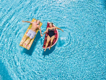 Directly above shot of people relaxing in swimming pool