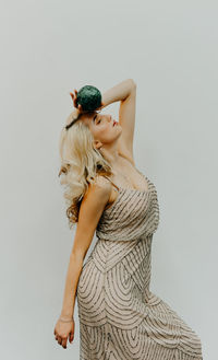 Midsection of woman standing against white background