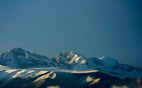 Scenic view of snowcapped mountains against clear blue sky