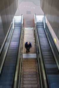 High angle view of man standing on escalator