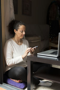 Woman using mobile phone at home