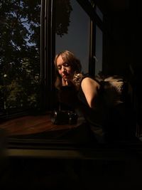 Beautiful woman sitting by window at home