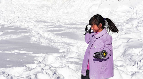 Full length of woman standing on field during winter