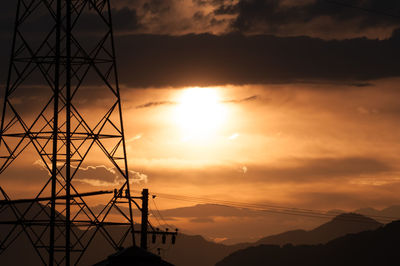 Silhouette mountains against dramatic sky during sunset