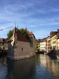 River amidst buildings in city against sky