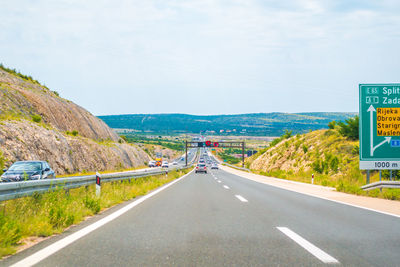 Road passing through mountains against sky