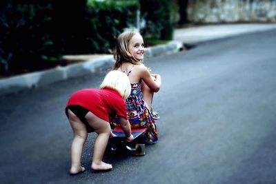 Portrait of young woman sitting on road