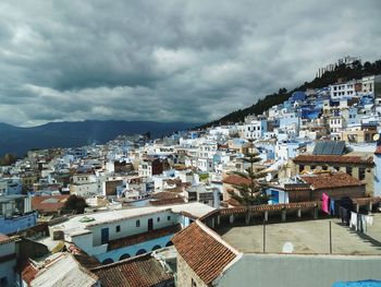 High angle shot of townscape against cloudy sky