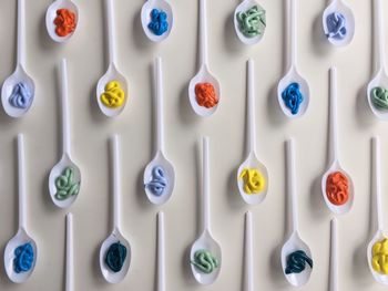 Directly above shot of watercolor paints in spoons arranged on table