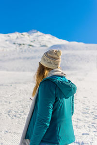 Woman in warm clothes while standing on snow covered land