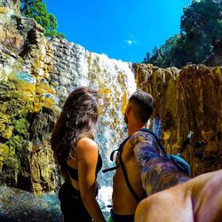 Rear view of people on cliff by sea