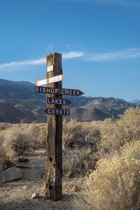 Wooden sign post  and arrows in eastern sierra nevada mountains  and desert landscape 