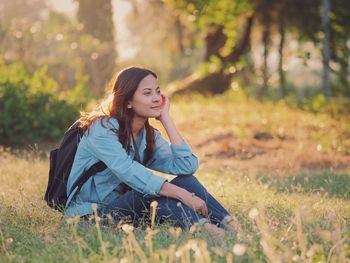 Young woman sitting on grassy field