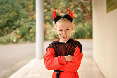 A girl dressed as a devil with horns