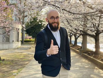 Portrait of bearded man standing against trees. sakura business investment 