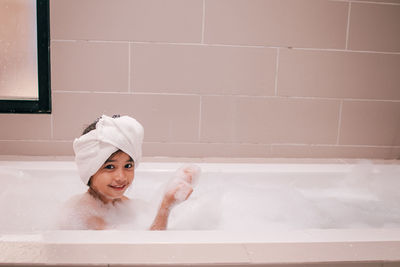 Little girl with bubbles in bathtub