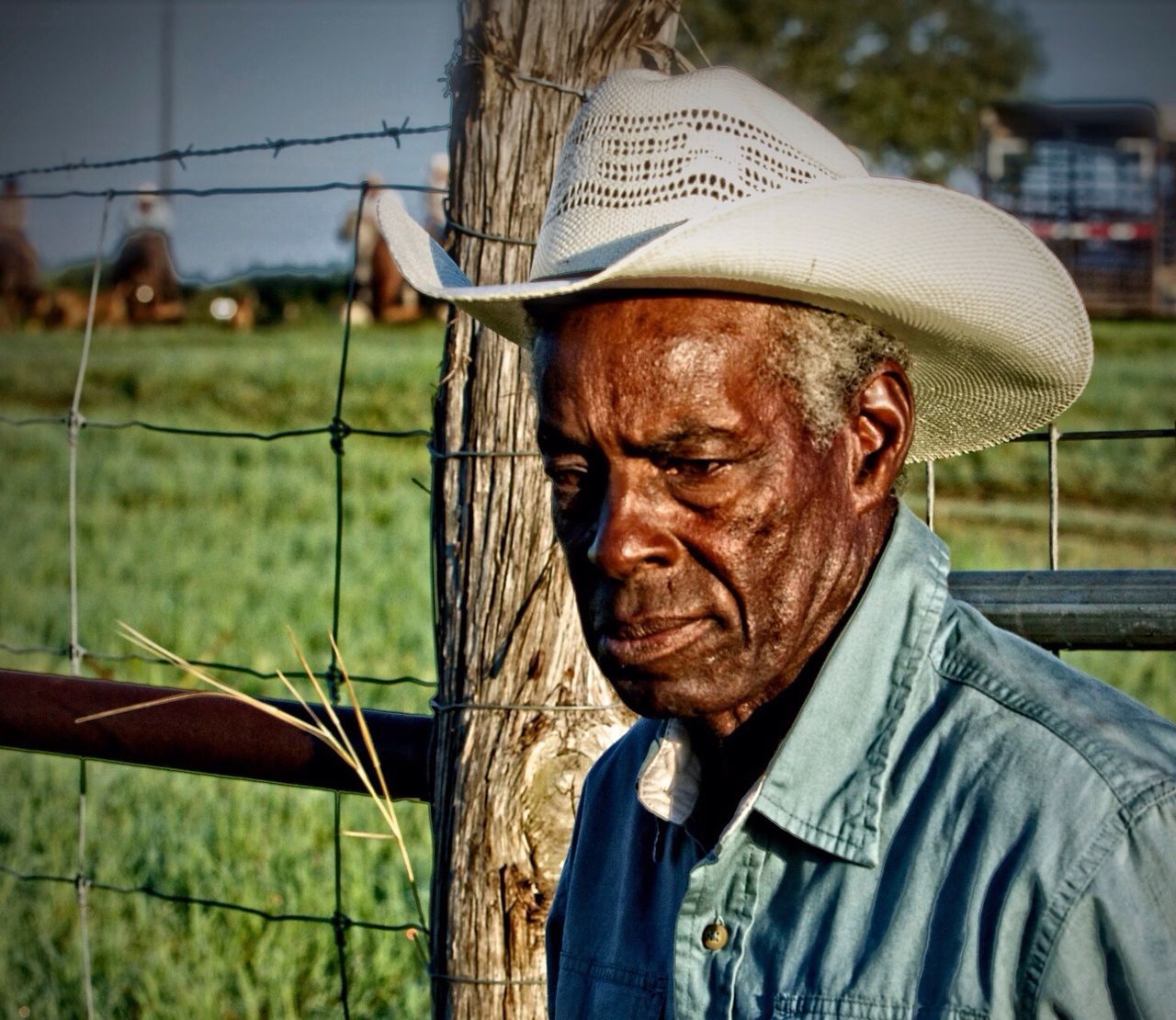 focus on foreground, close-up, portrait, front view, lifestyles, young adult, outdoors, day, leisure activity, person, side view, field, horse, standing, casual clothing, young men, looking at camera, fence